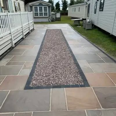 Driveway and patio finished with grey porcelain slabs and a gravel border in Wirral